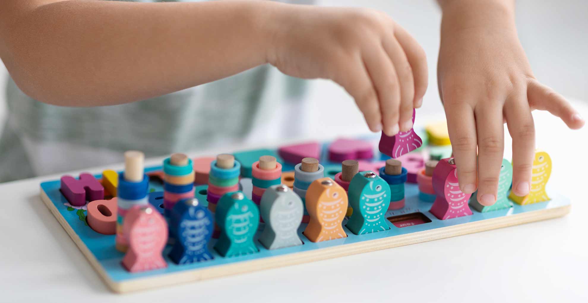 A young child playing with a wooden puzzle of teddy bears